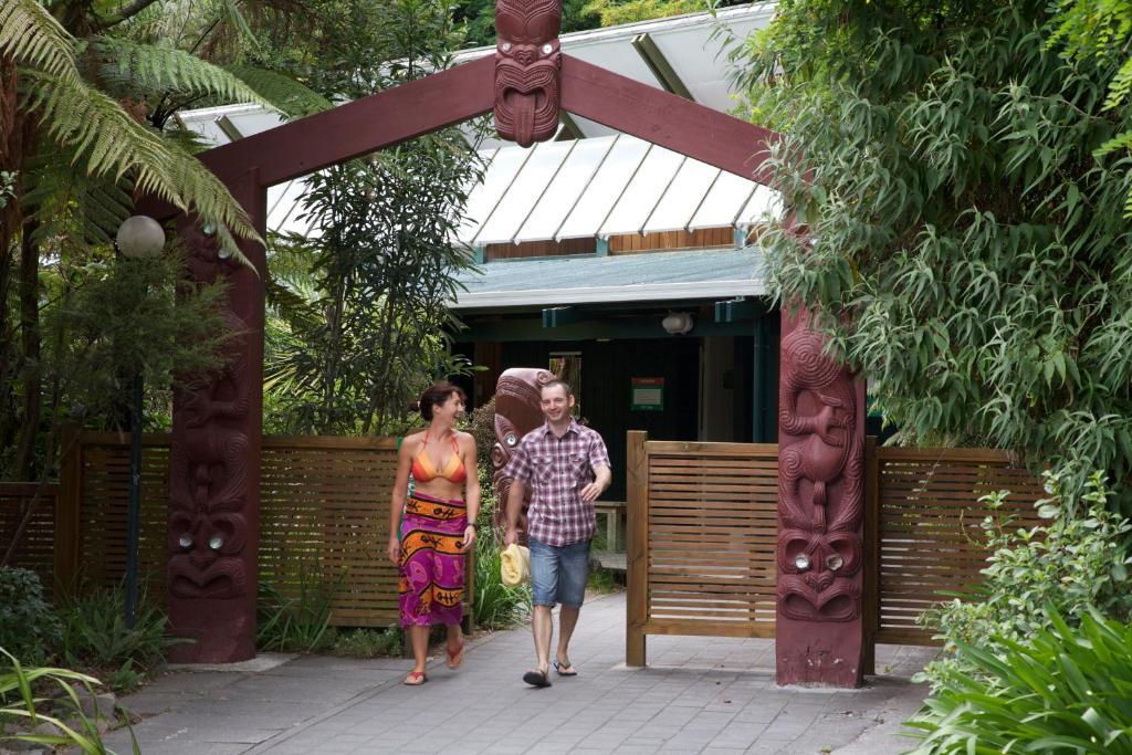 陶波德布雷思汽车旅馆酒店 外观 照片 The photo depicts a welcoming entrance, marked by a decorative archway featuring traditional cultural carvings. Two individuals are walking through the entrance: one is a woman wearing a vibrant, patterned dress, and the other is a man dressed casual