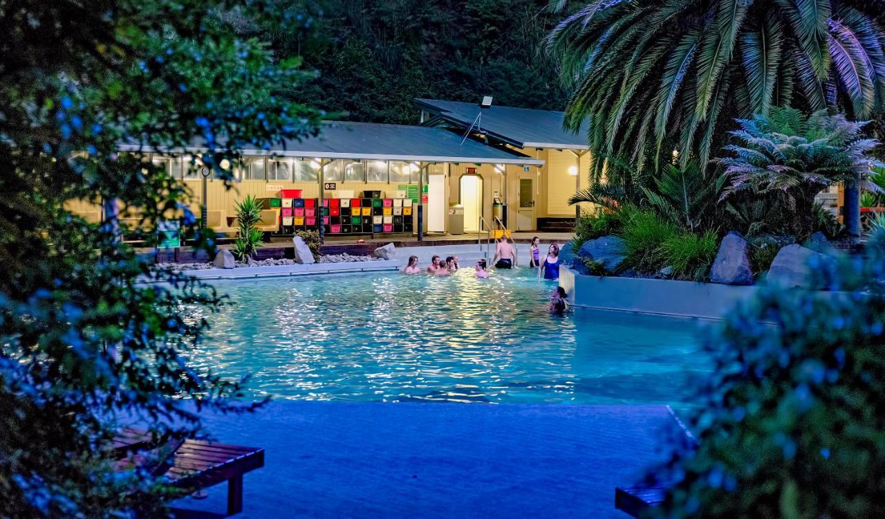 陶波德布雷思汽车旅馆酒店 外观 照片 The photo shows a scenic pool area illuminated by soft lighting during the evening. People can be seen enjoying the water, suggesting a relaxed atmosphere. In the background, there's a building with large windows, which appears to be part of a facili